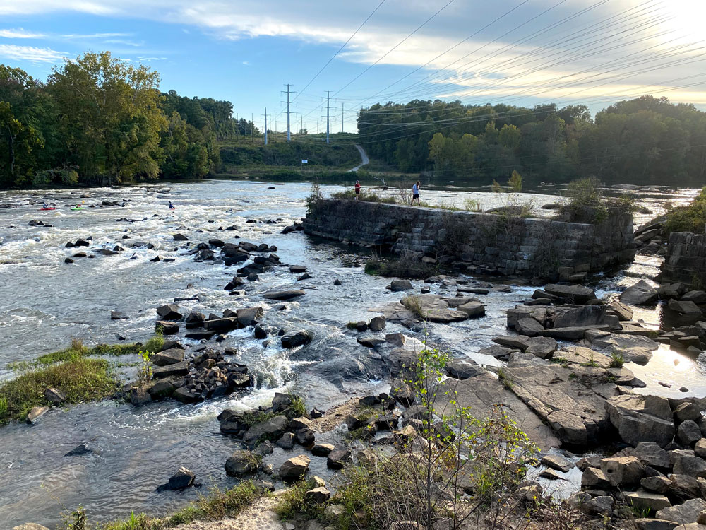 river with rapids over rocks and blue sky