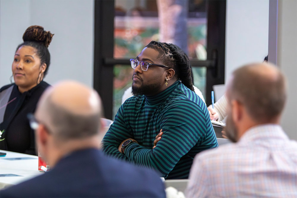 man in glasses and other group of employees
